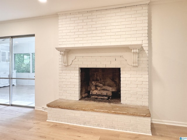 detailed view of crown molding, wood finished floors, baseboards, a brick fireplace, and recessed lighting