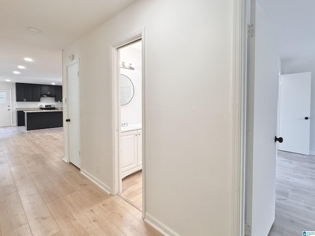 hall with light wood-style flooring, recessed lighting, and baseboards