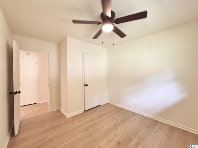 unfurnished bedroom featuring light wood-style floors, baseboards, a ceiling fan, and a closet