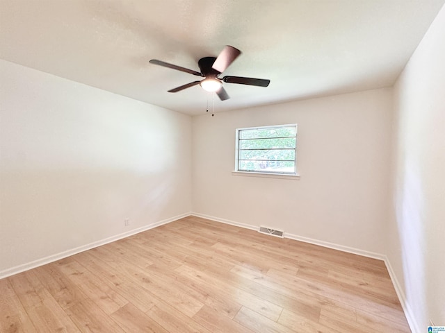 empty room featuring light wood finished floors, baseboards, and ceiling fan
