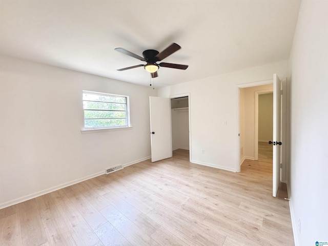 unfurnished bedroom with light wood-style floors, a closet, baseboards, and a ceiling fan