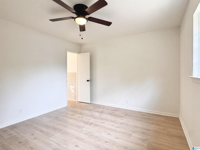 spare room featuring light wood-style flooring, ceiling fan, and baseboards