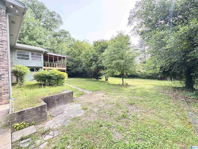 view of grassy yard with a sunroom