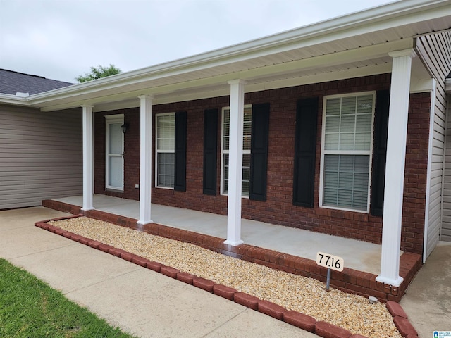 view of property exterior featuring a porch and brick siding