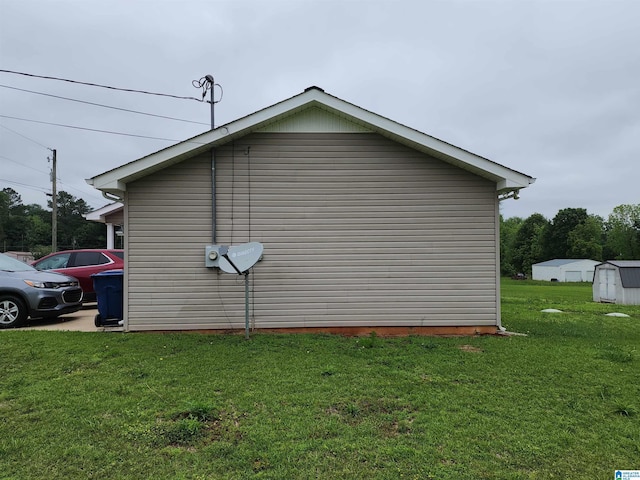 view of side of property with a yard and an outbuilding