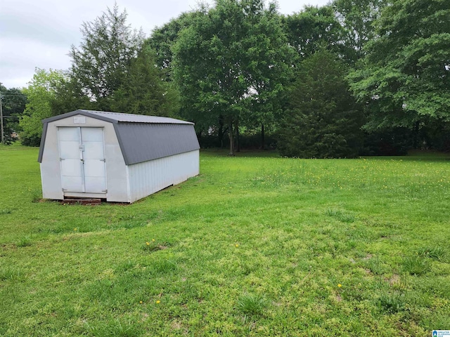 view of grassy yard with an outdoor structure and a storage shed