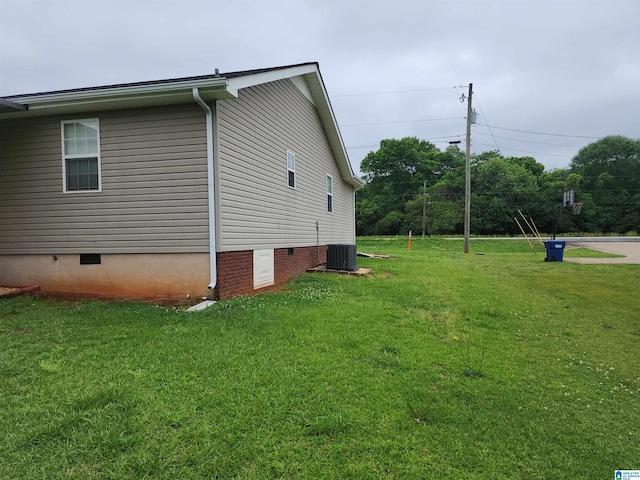 view of side of property with crawl space, a yard, and cooling unit