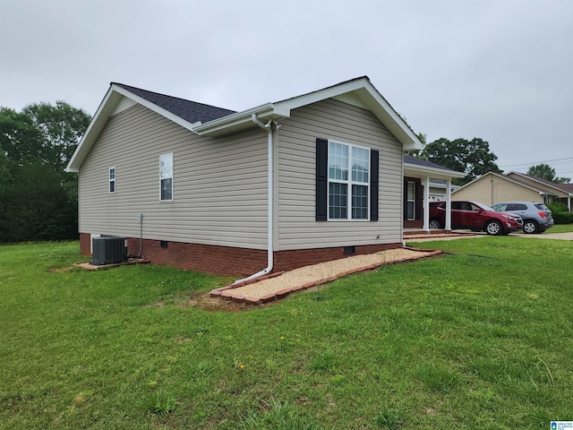 view of side of home featuring crawl space, a yard, and cooling unit