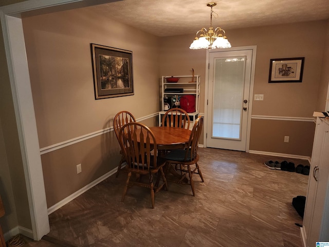dining room featuring a chandelier and baseboards