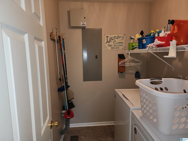 laundry room featuring electric panel, washing machine and dryer, and baseboards