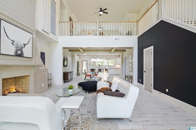 2126 Raines Run, Birmingham, AL 35242 - living area featuring a high ceiling, a ceiling fan, baseboards, a premium fireplace, and a chandelier