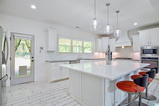 2126 Raines Run, Birmingham, AL 35242 - kitchen with appliances with stainless steel finishes, custom range hood, a kitchen island, decorative backsplash, and crown molding