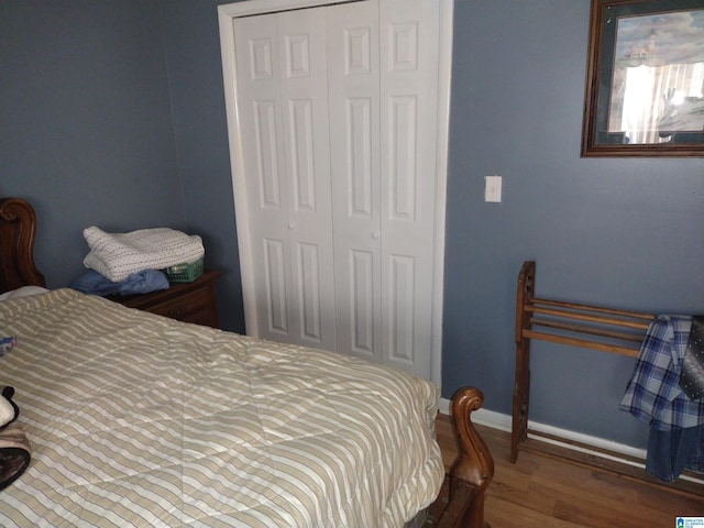 bedroom with a closet, wood finished floors, and baseboards