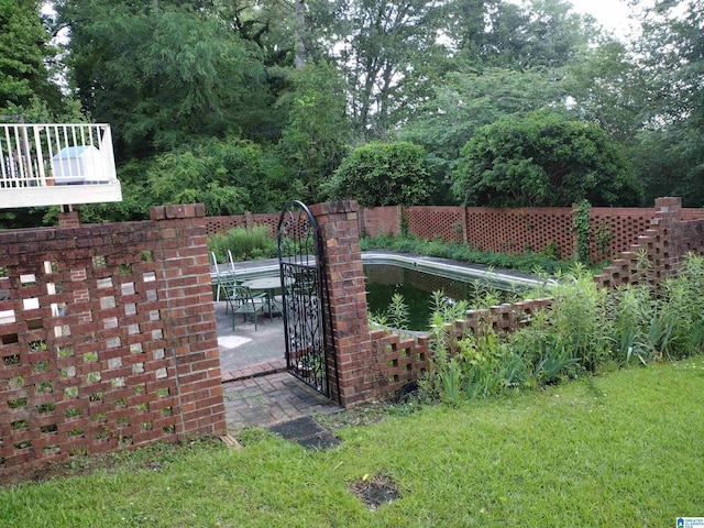 gate with a lawn and a patio area