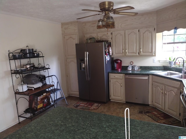 kitchen with stainless steel appliances, a sink, ceiling fan, dark countertops, and baseboards