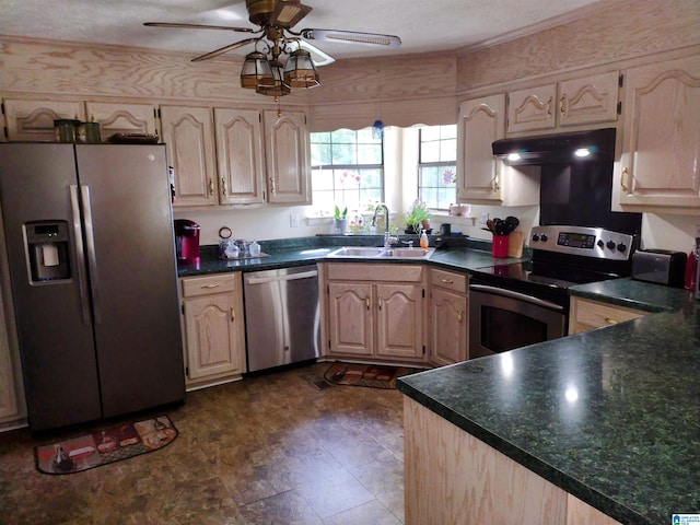 kitchen featuring appliances with stainless steel finishes, a sink, ceiling fan, dark countertops, and under cabinet range hood