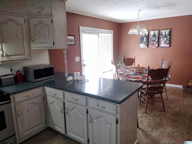 kitchen with a peninsula, a chandelier, range, dark countertops, and decorative light fixtures