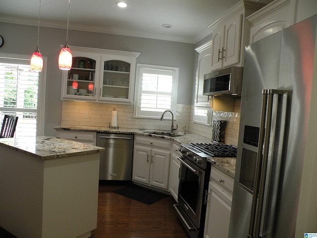 kitchen with premium appliances, a sink, white cabinetry, dark wood-style floors, and glass insert cabinets