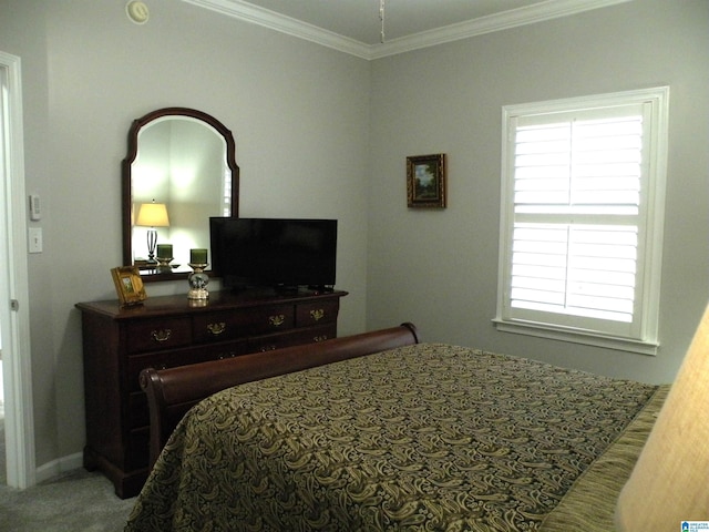 carpeted bedroom with ornamental molding and baseboards