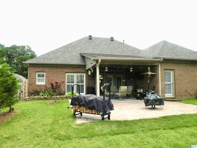 rear view of property featuring a fire pit, roof with shingles, and brick siding