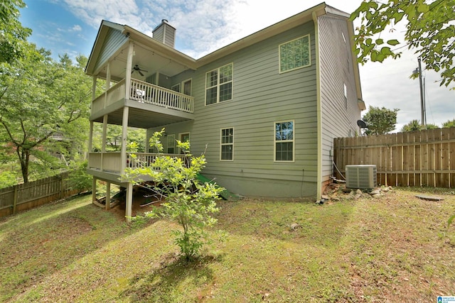 rear view of house featuring a balcony, ceiling fan, fence, a chimney, and a deck