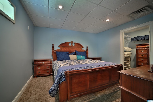 bedroom with dark colored carpet, a drop ceiling, baseboards, recessed lighting, and a walk in closet