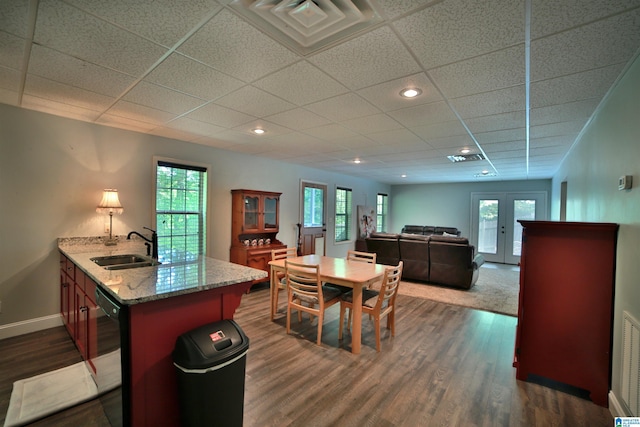 dining room with baseboards, french doors, dark wood-style floors, a drop ceiling, and recessed lighting