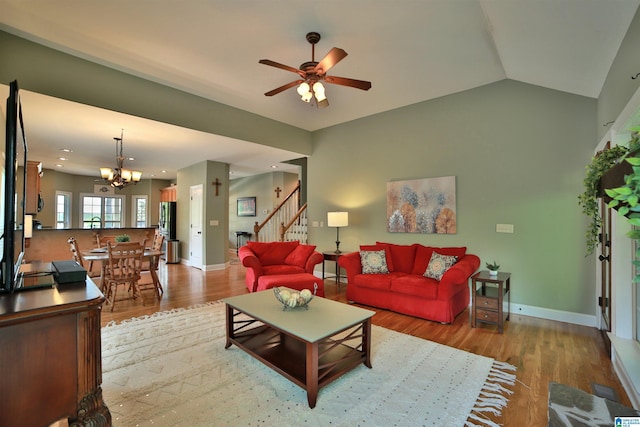 living room featuring a chandelier, stairway, light wood finished floors, ceiling fan, and baseboards