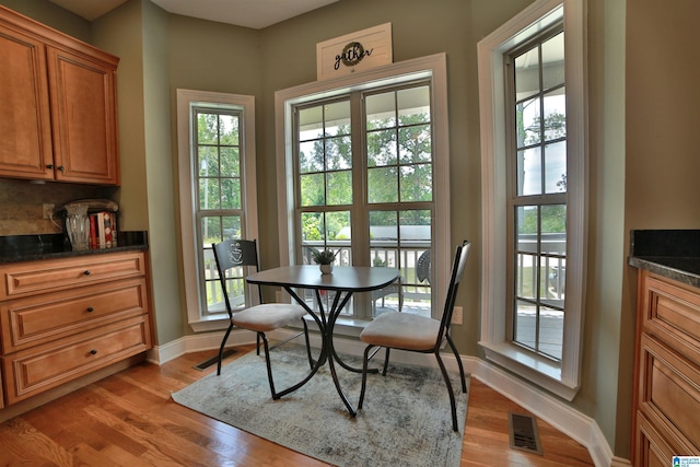 dining area featuring healthy amount of natural light, baseboards, and light wood-style flooring