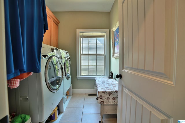 clothes washing area featuring washer and clothes dryer, cabinet space, light tile patterned flooring, and baseboards