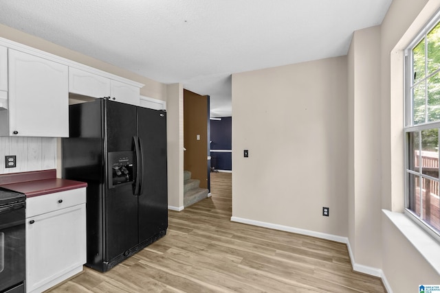 5826 Willow Crest Dr, Pinson, AL 35126 - kitchen with black appliances, white cabinetry, light wood finished floors, and baseboards