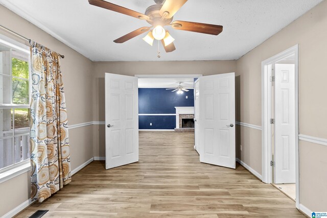 5826 Willow Crest Dr, Pinson, AL 35126 - spare room with ceiling fan, light wood-style flooring, and a fireplace