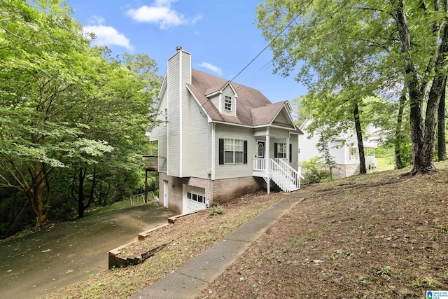 5826 Willow Crest Dr, Pinson, AL 35126 - view of front facade featuring a garage, concrete driveway, and a chimney