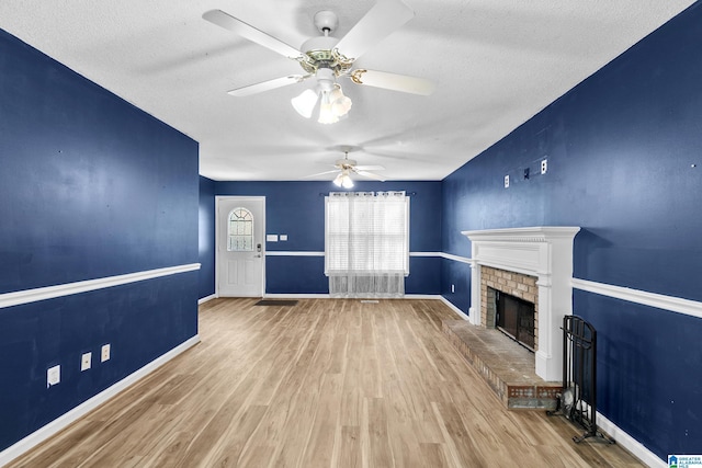5826 Willow Crest Dr, Pinson, AL 35126 - unfurnished living room with ceiling fan, a fireplace, wood finished floors, a textured ceiling, and baseboards