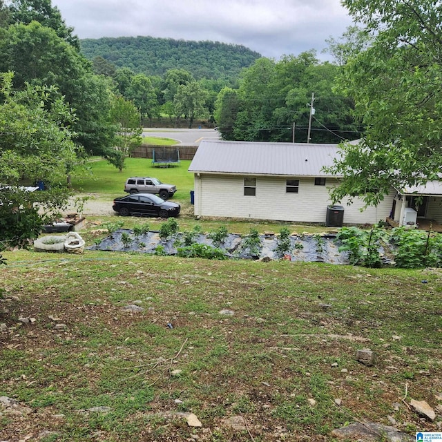 18981 Remlap Dr, Remlap, AL 35133 - view of side of property featuring a metal roof, a forest view, and a yard