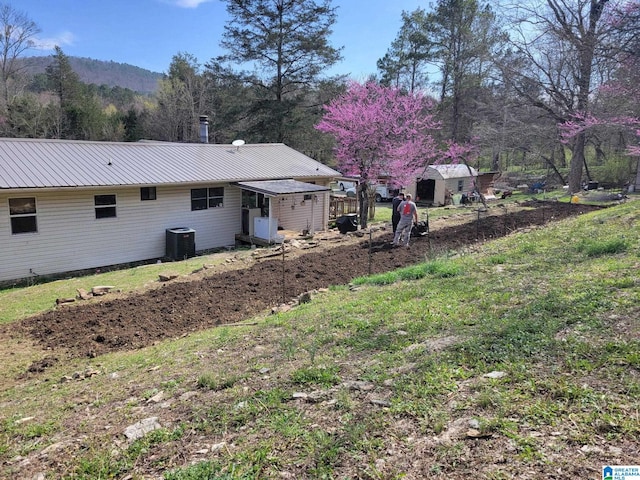 18981 Remlap Dr, Remlap, AL 35133 - rear view of property with central AC unit, a storage shed, metal roof, and an outbuilding