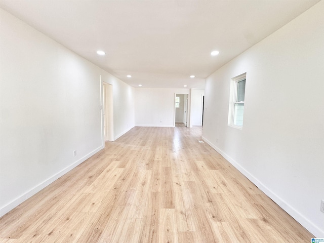 spare room featuring recessed lighting, light wood-style floors, and baseboards