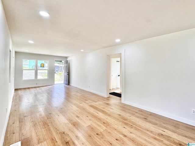 spare room featuring light wood finished floors, recessed lighting, and baseboards