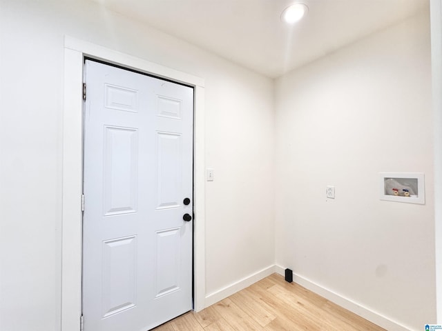 clothes washing area with hookup for a washing machine, light wood-style flooring, and baseboards