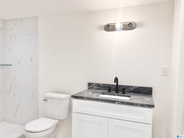 full bathroom with vanity, toilet, and tiled shower