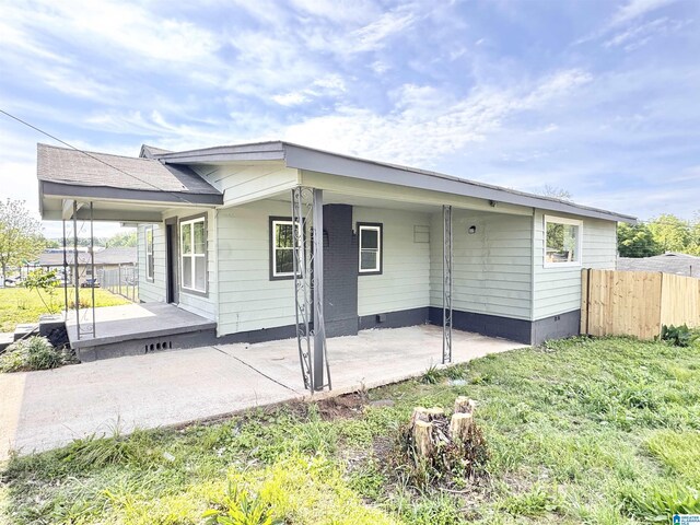 back of property with fence and crawl space