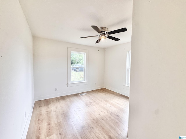empty room with light wood-type flooring, ceiling fan, and baseboards