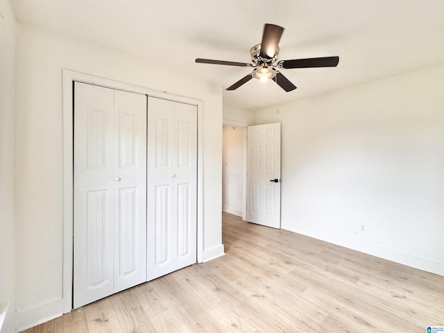 unfurnished bedroom with a closet, light wood finished floors, baseboards, and a ceiling fan