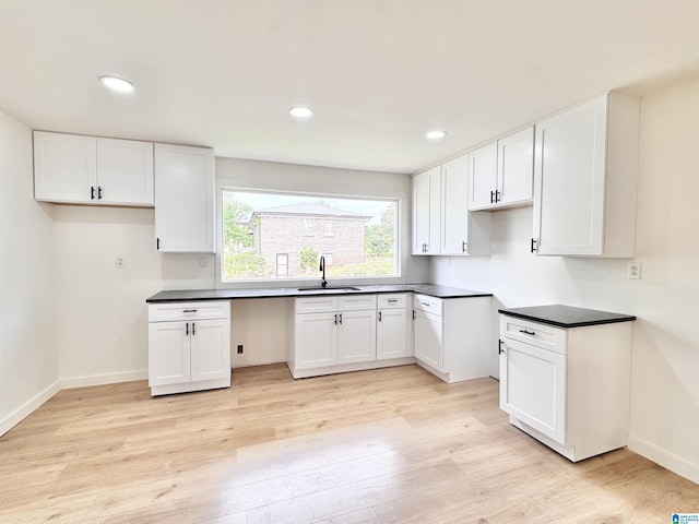 kitchen featuring a sink, white cabinets, light wood-style flooring, and recessed lighting