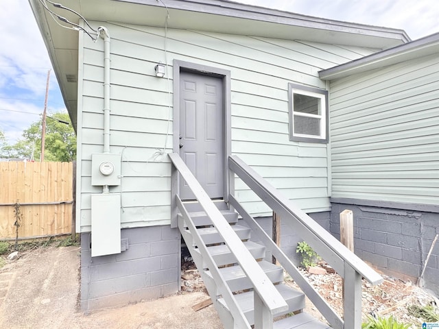doorway to property featuring fence