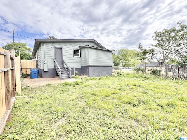 back of house with a fenced backyard and entry steps