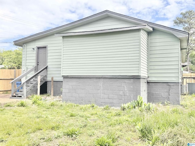 view of side of property featuring fence and entry steps