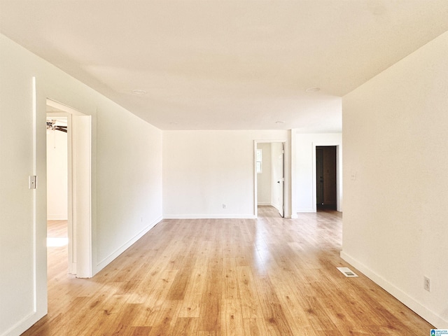 spare room featuring light wood-style floors and baseboards