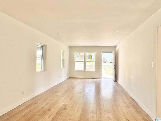spare room with light wood-style floors and baseboards