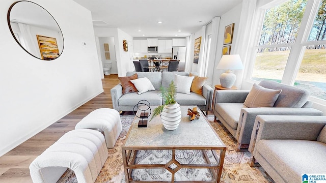living room featuring light wood finished floors, recessed lighting, and baseboards